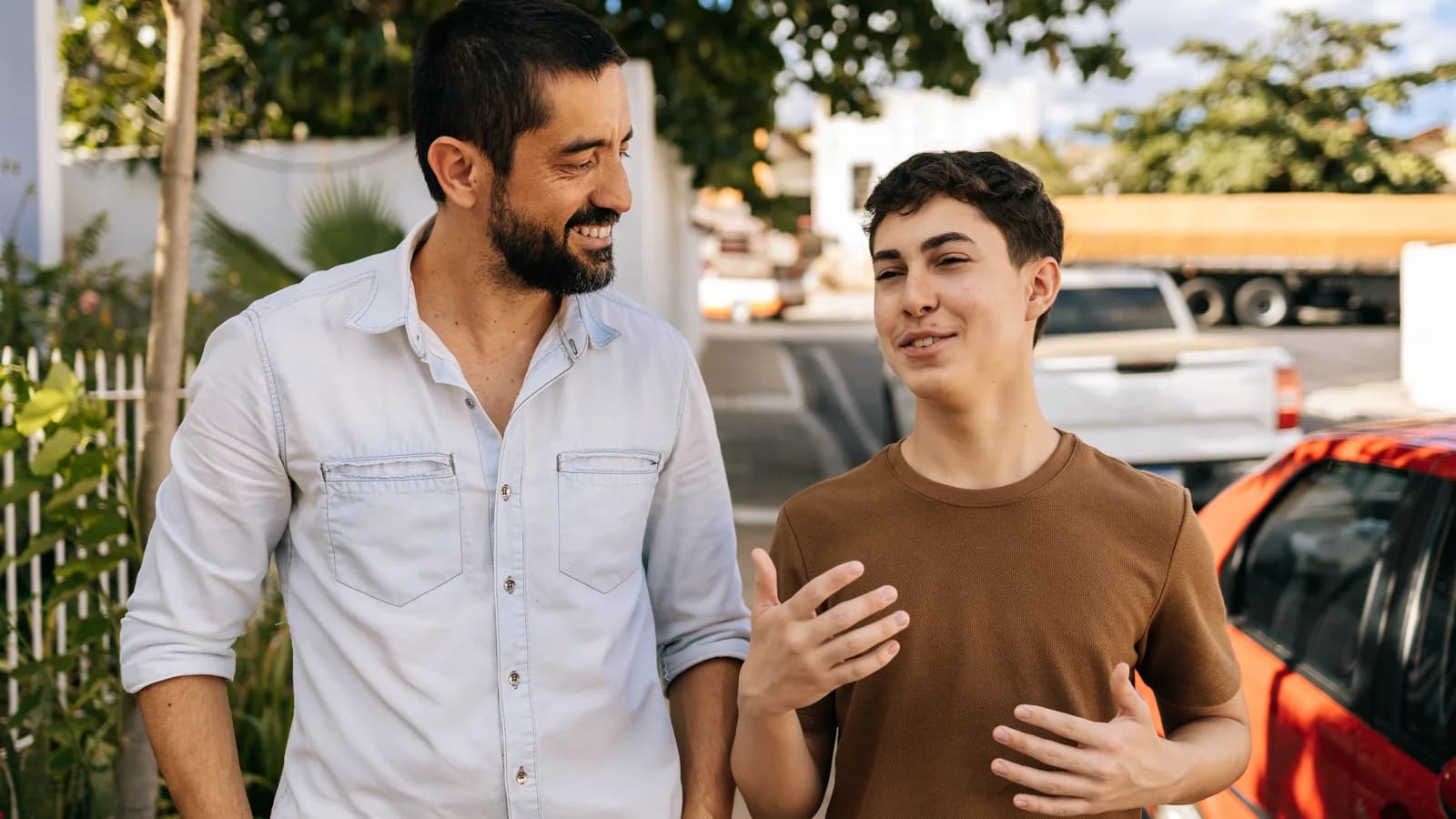Father and teenage son walking together after treatment during a supportive conversation