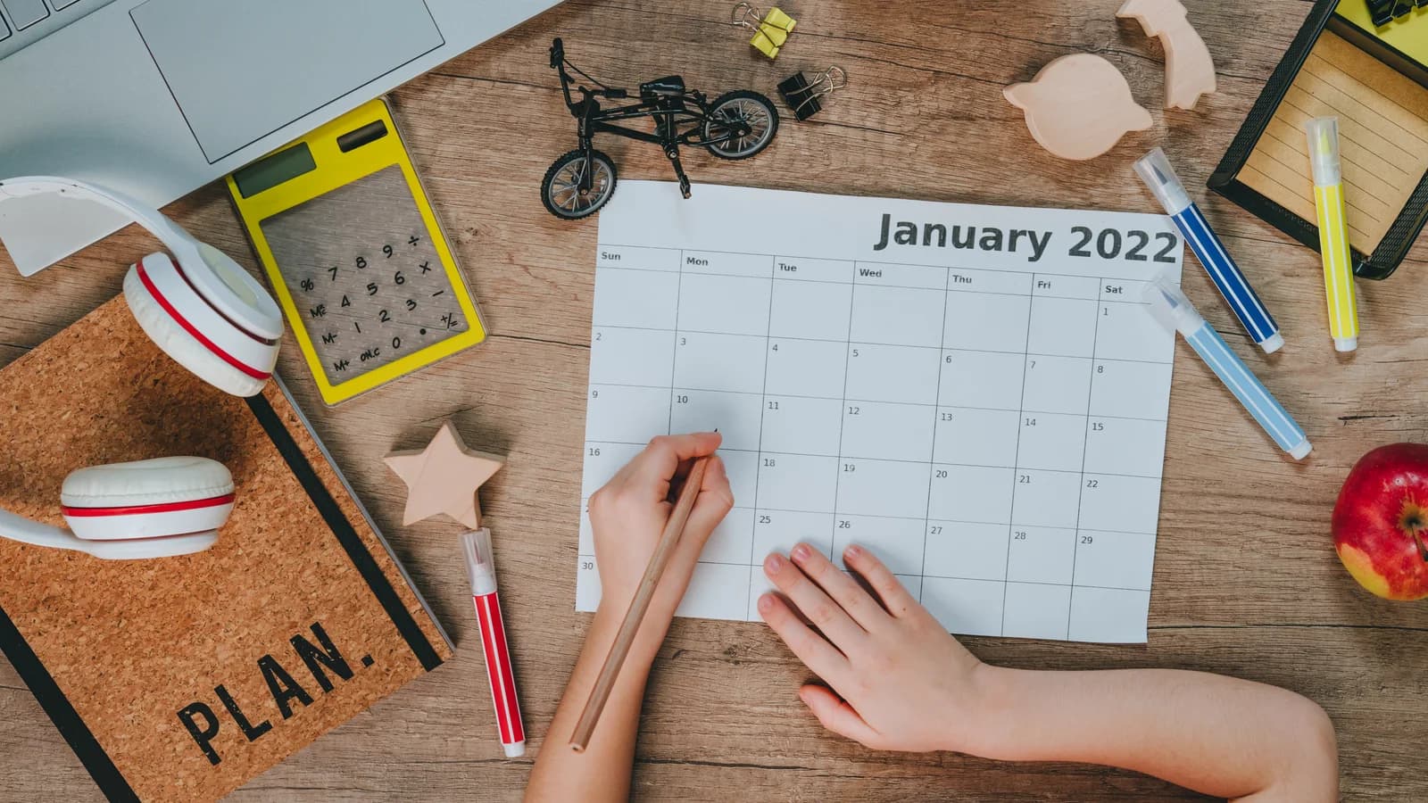 Hands using a calendar for planning routines after teen residential treatment