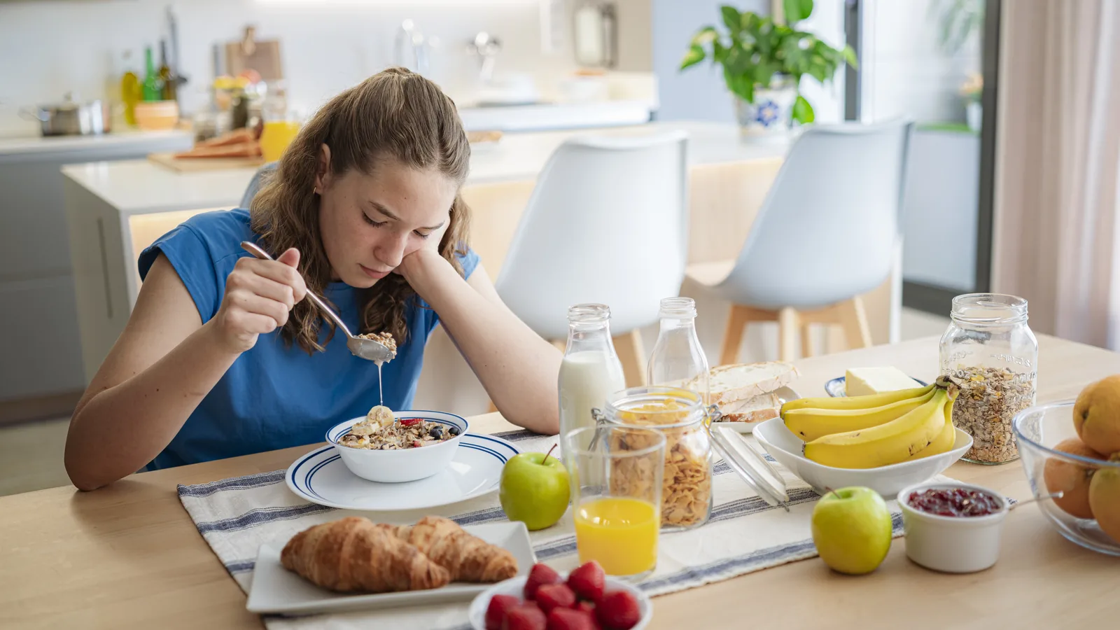 Teen girl looking down at breakfast cereal for an ARFID and food avoidance guide
