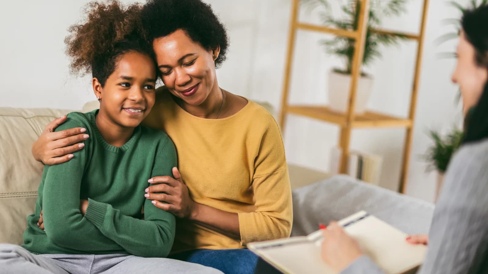 Mother and teenage daughter sitting with a therapist during a family therapy session