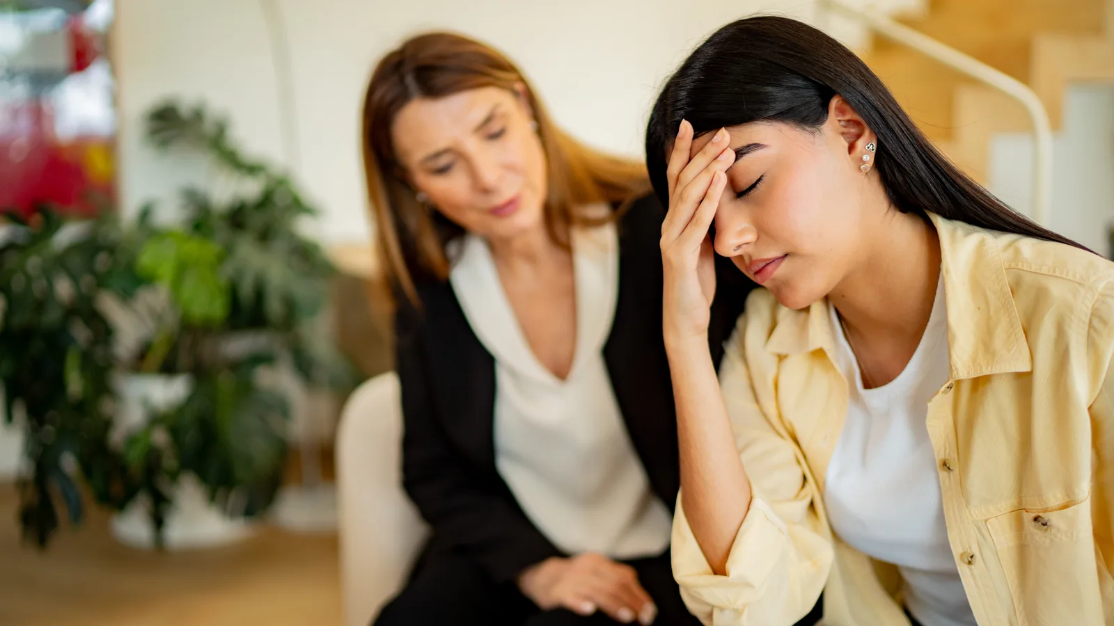Therapist sitting beside a distressed teen girl during a counseling session