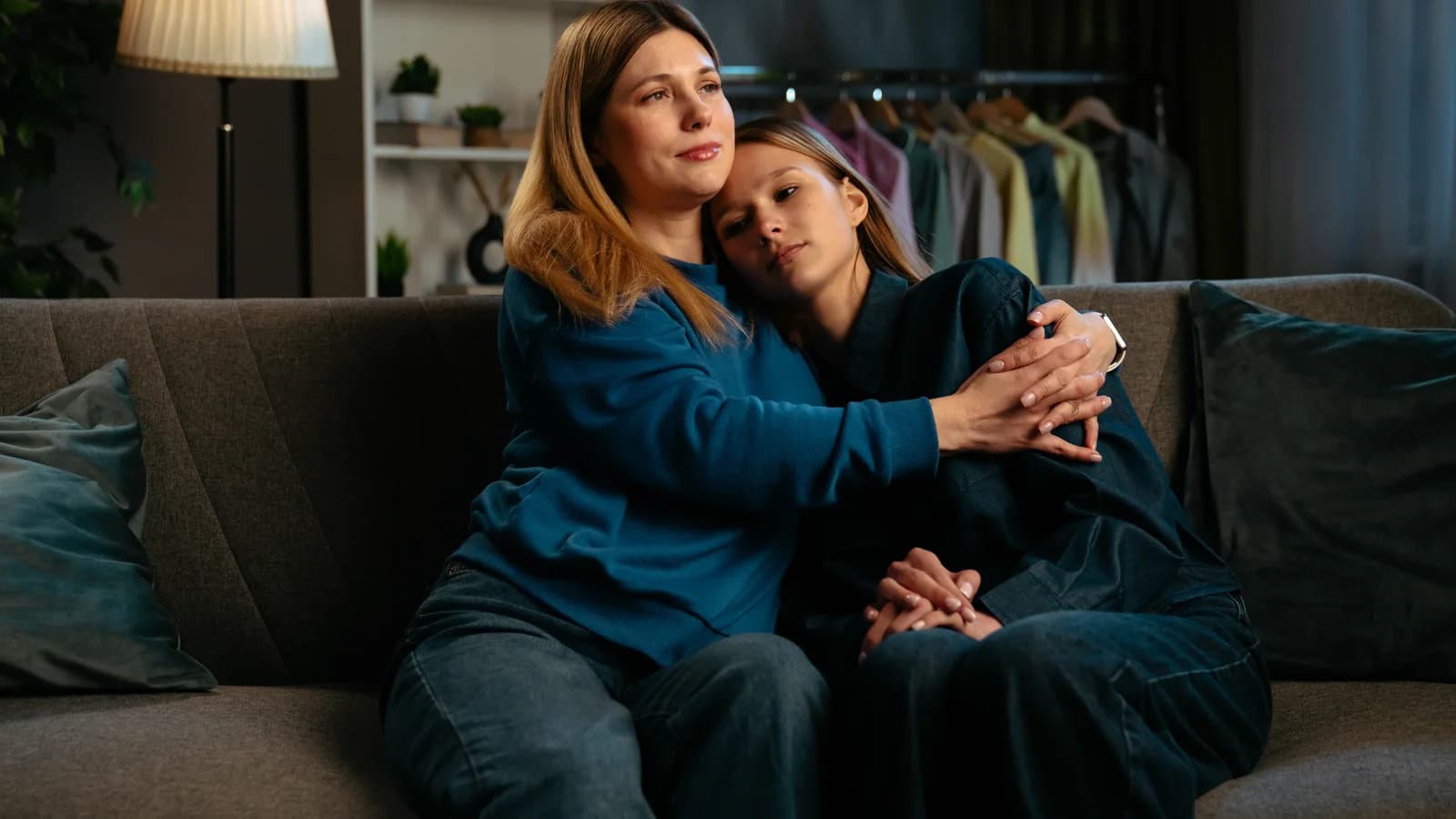 Mother comforting withdrawn teenage daughter during an emotional conversation at home