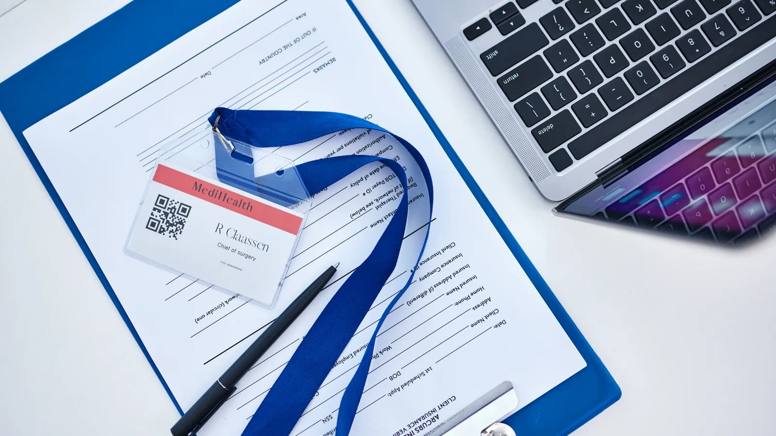 Health insurance paperwork, ID badge, and laptop for a teen treatment verification guide
