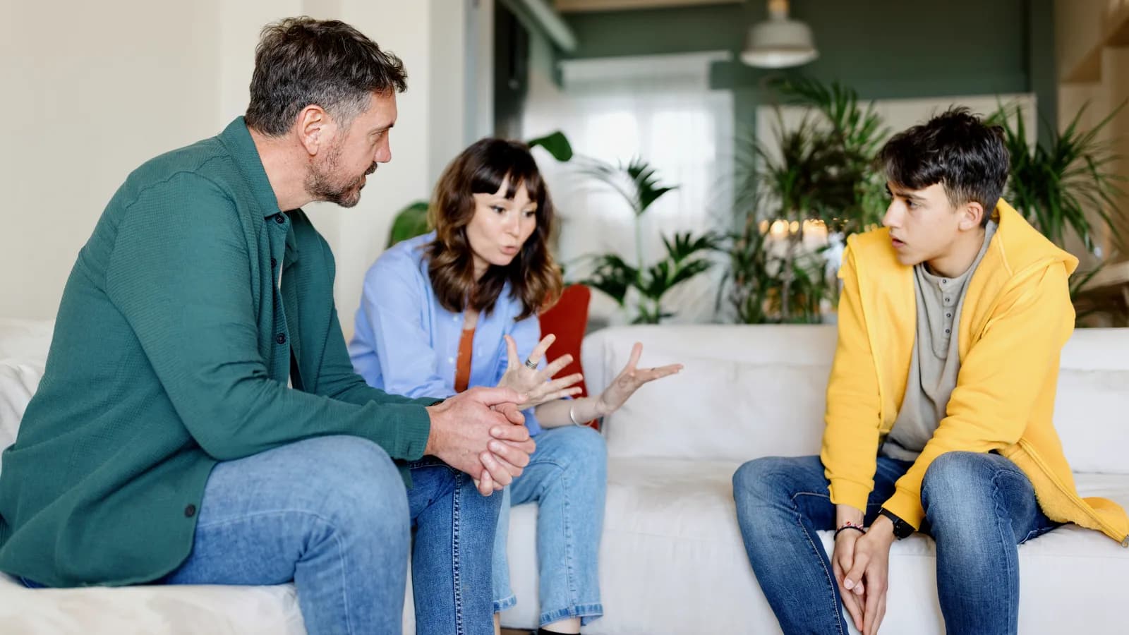 Parents talking with their teenage son at home for a guide about conflict repair and boundaries