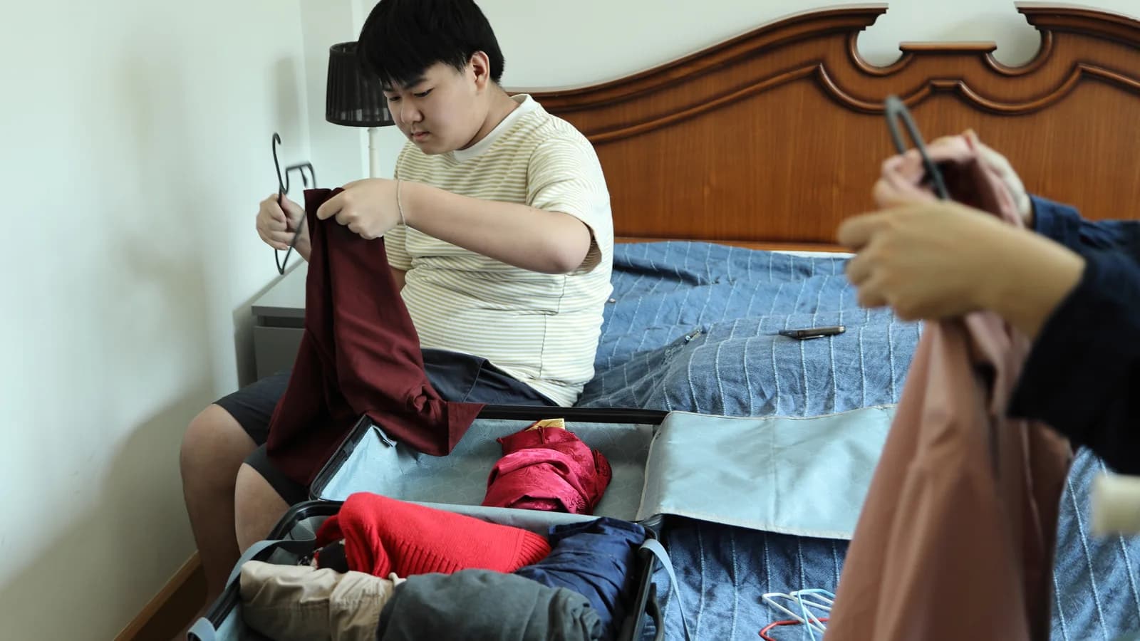 Teen packing a bag with family support before entering residential treatment