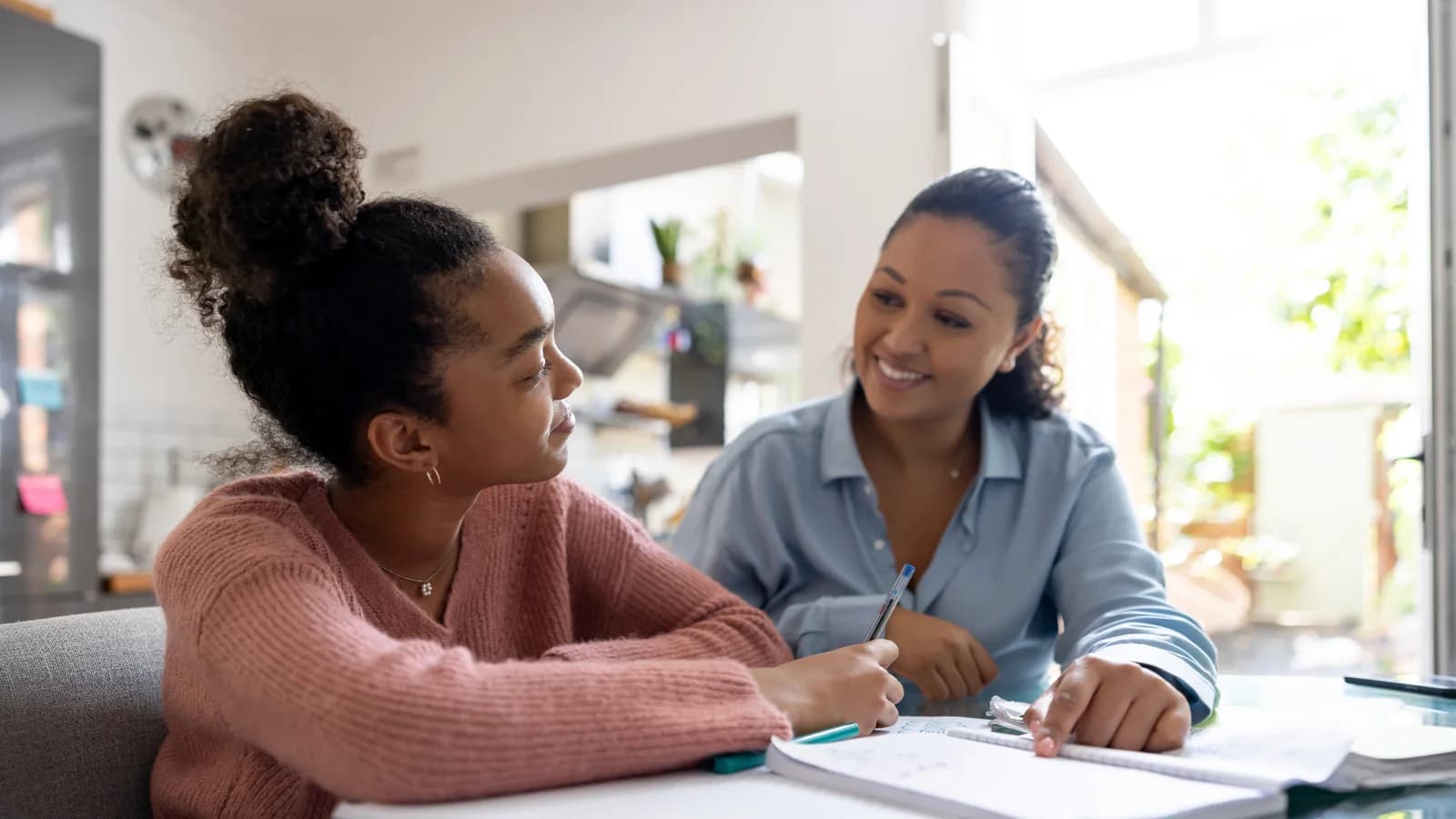 Teen girl completing schoolwork with adult support during treatment planning
