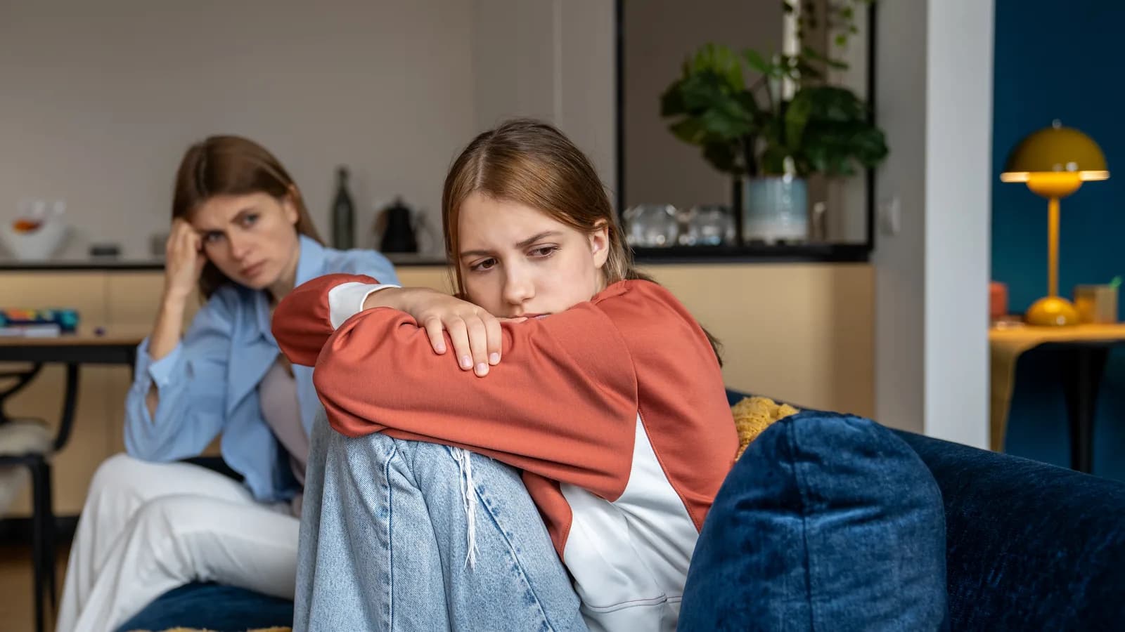 Mother sitting near withdrawn teenage daughter for a guide about school refusal and anxiety avoidance