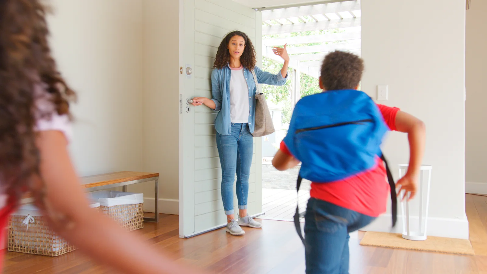Parent encouraging children at the front door for a guide about school refusal and anxiety