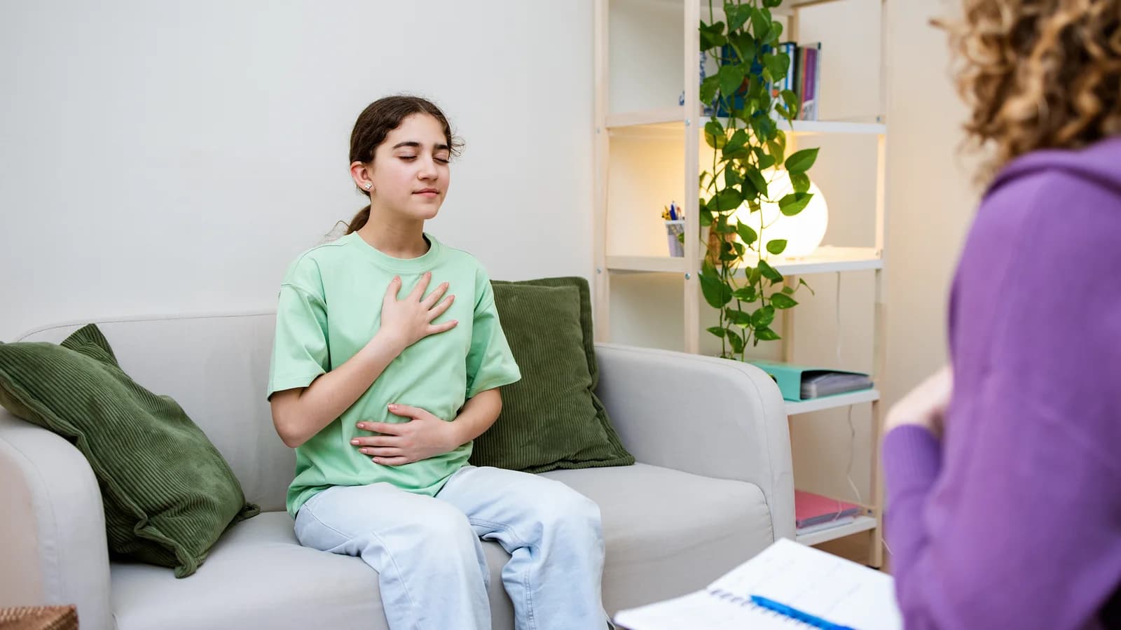 Teen practicing a breathing exercise in therapy for anxiety support
