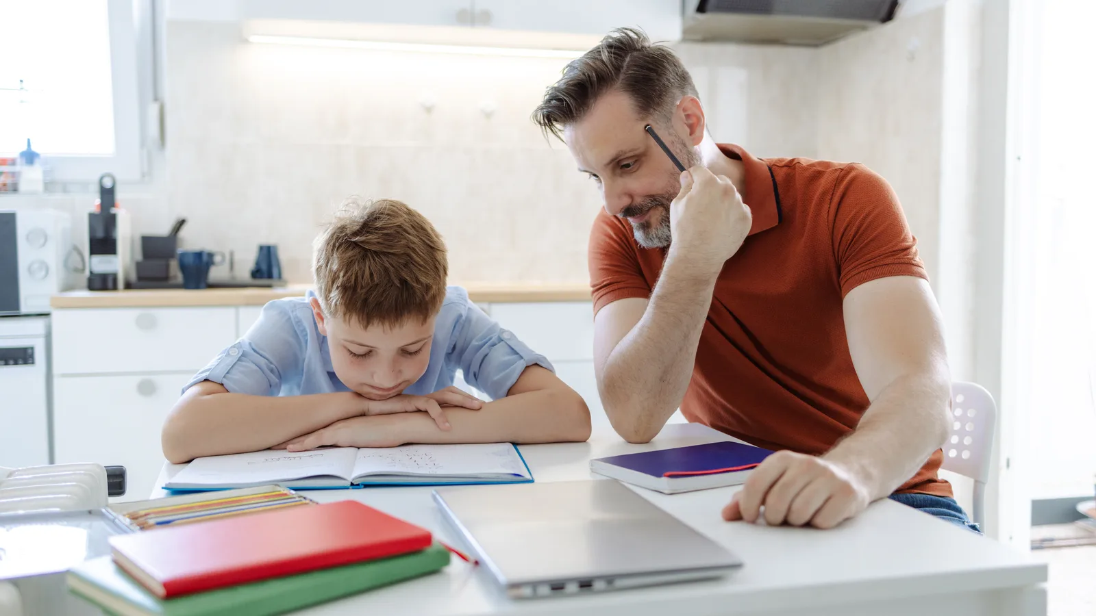 Father helping teenage son with schoolwork for a guide about ADHD and executive functioning support