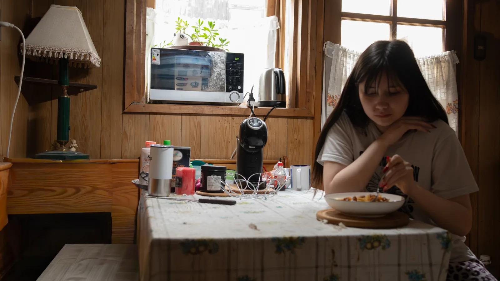 Young woman eating alone in low light for a guide about binge eating and shame
