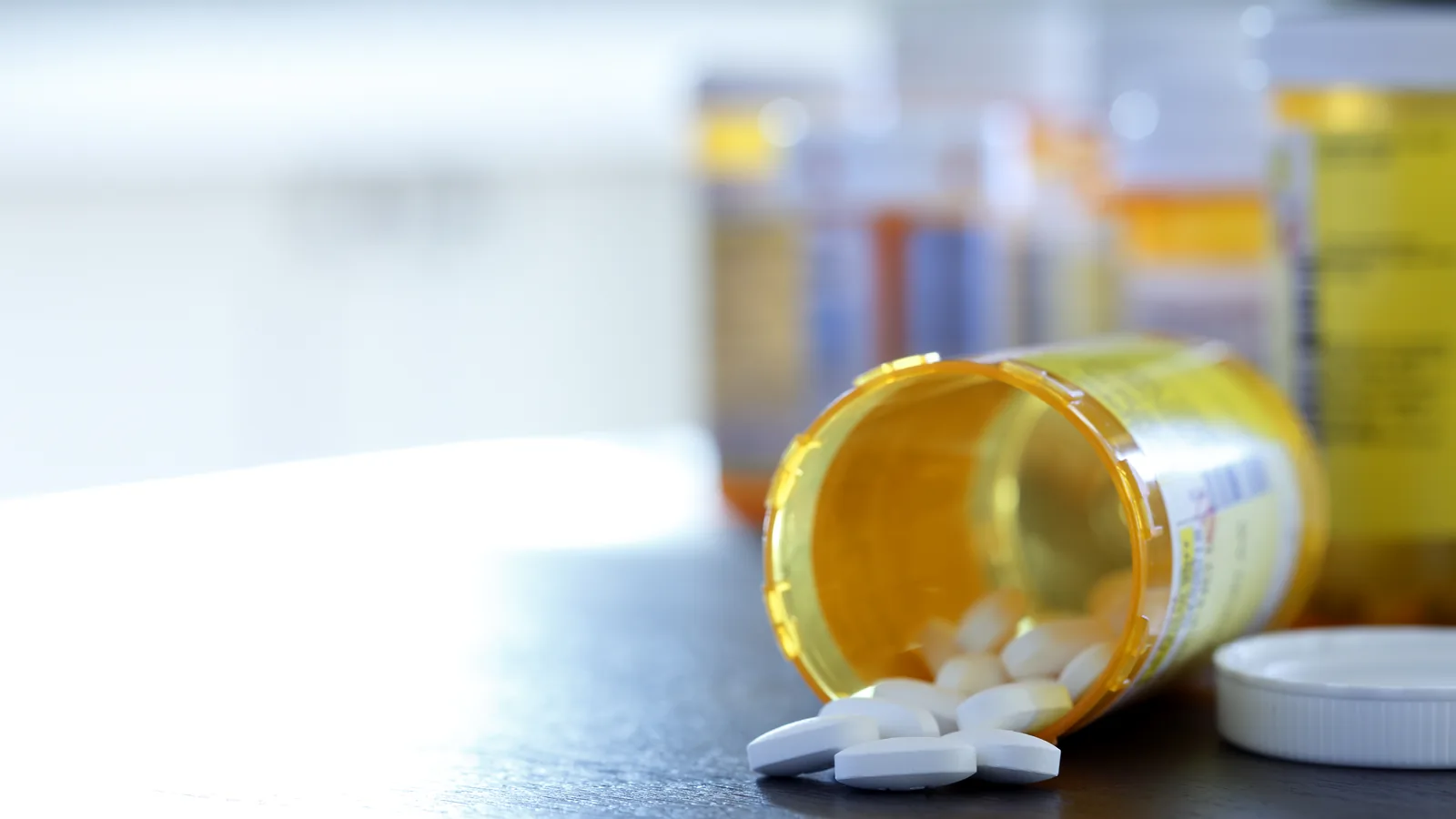 Open prescription bottle with pills on a table for a parent guide about medication safety