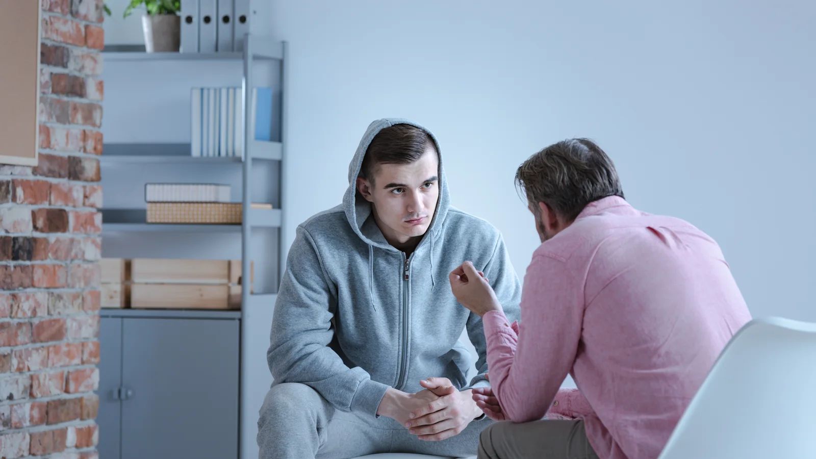 Therapist explaining a recovery plan to a troubled teen boy for a substance use and mental health guide