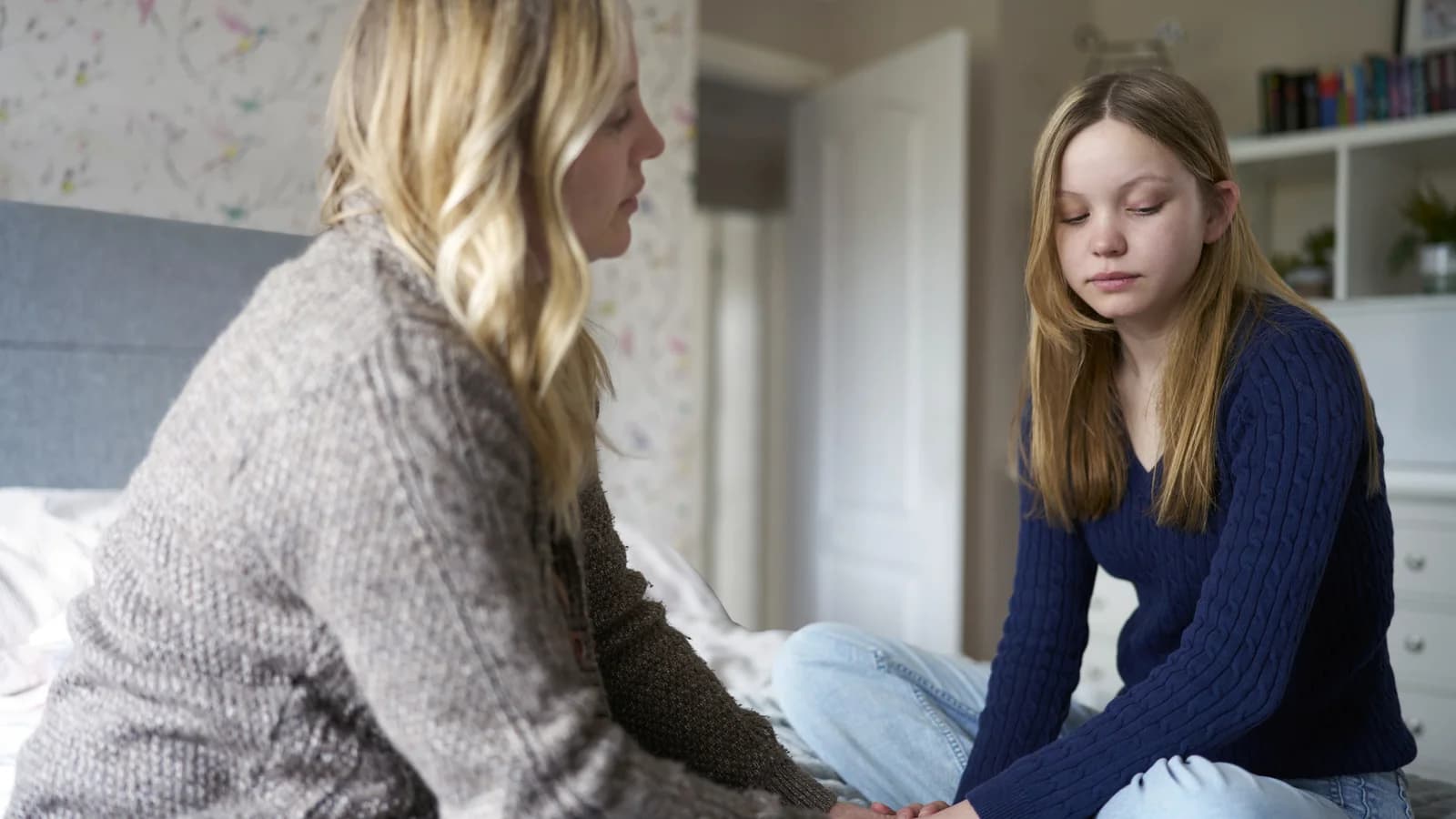 Mother sitting with withdrawn teenage daughter at home when outpatient therapy may not be enough
