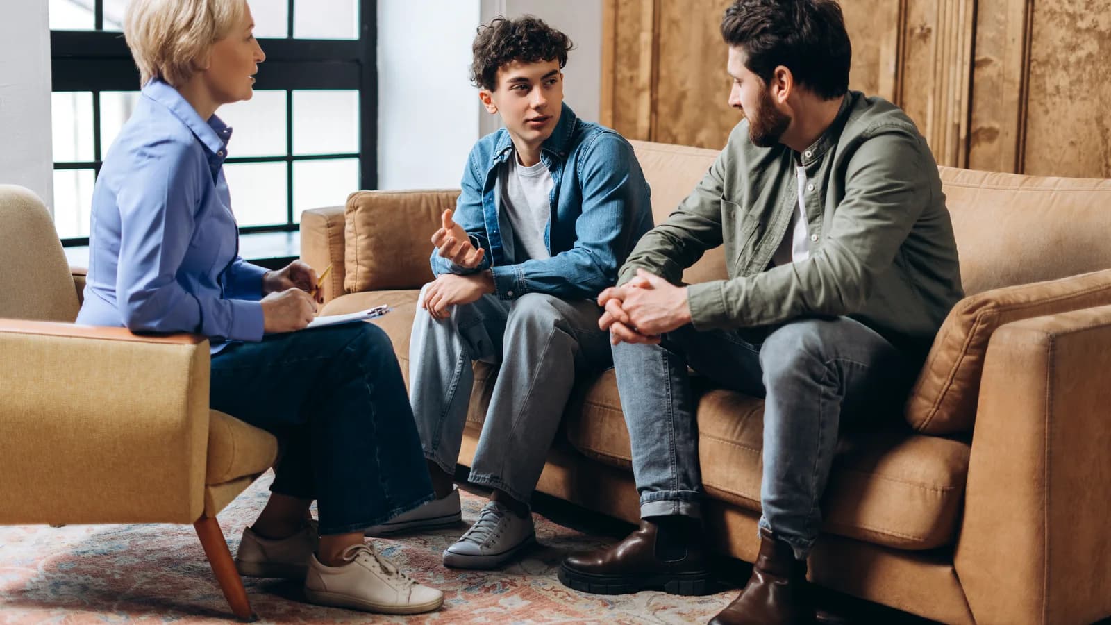 Father and teenage son talking with a psychologist when outpatient therapy may not be enough