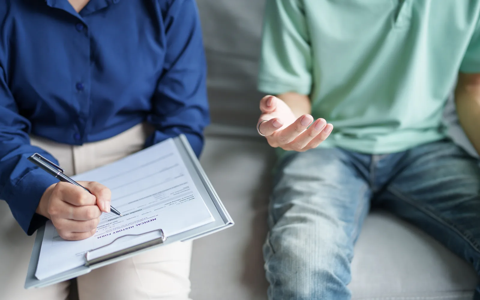 Clinician reviewing medication and treatment planning documents with a teen and parent.