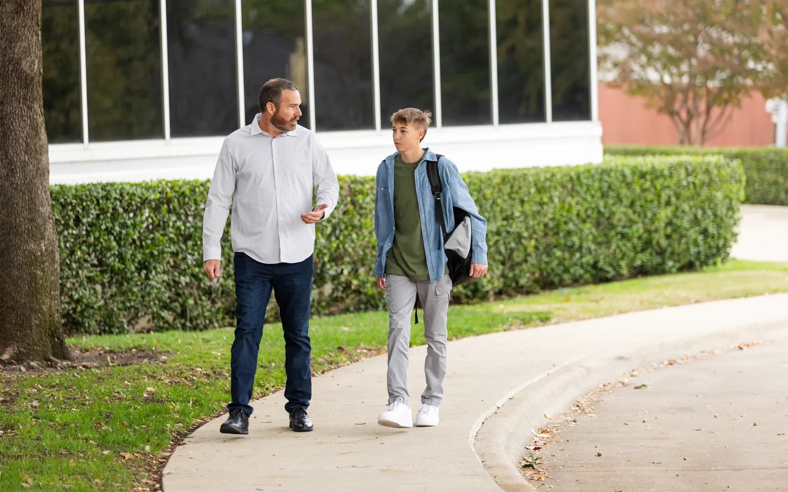 Teen walking outside with a supportive adult near a supervised treatment setting.